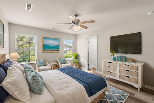 bedroom with multiple windows, ceiling fan, and dark wood-type flooring