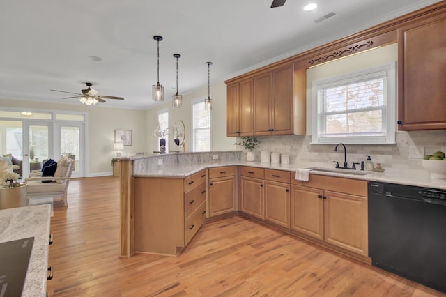 kitchen featuring pendant lighting, dishwasher, sink, kitchen peninsula, and light wood-type flooring