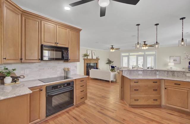 kitchen featuring tasteful backsplash, light stone counters, black appliances, light hardwood / wood-style floors, and decorative light fixtures