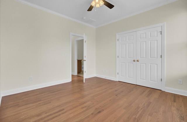 unfurnished bedroom with hardwood / wood-style flooring, ornamental molding, ceiling fan, and a closet