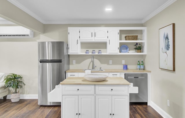 kitchen with dark wood-type flooring, sink, ornamental molding, appliances with stainless steel finishes, and white cabinets