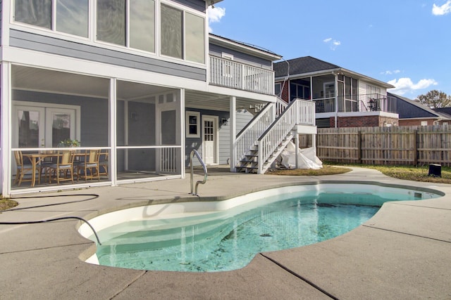 view of swimming pool with a patio area and a sunroom