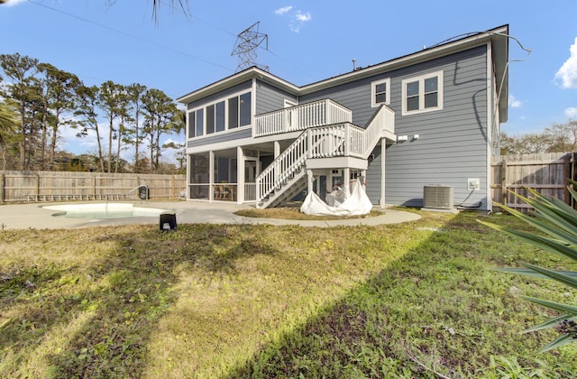 rear view of house featuring a swimming pool, cooling unit, a yard, a sunroom, and a patio area