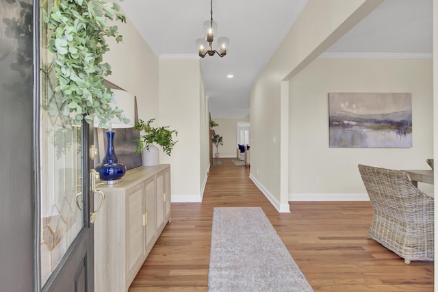 foyer featuring ornamental molding, a chandelier, and light hardwood / wood-style flooring