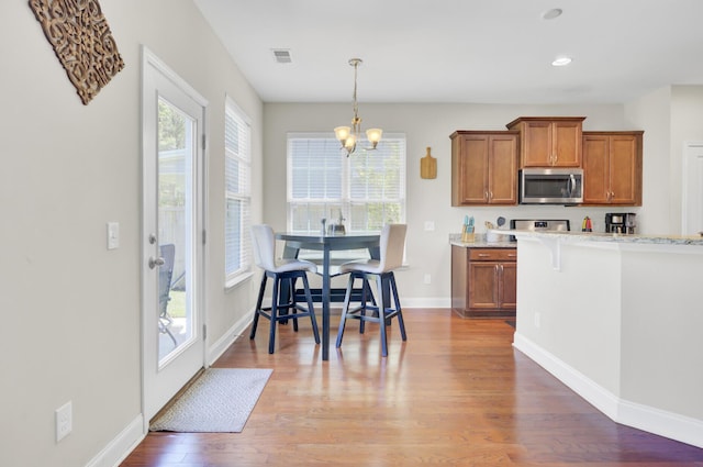 308 Legendres Dr, Goose Creek, SC 29445 - kitchen with stainless steel microwave, brown cabinets, a chandelier, plenty of natural light, and recessed lighting