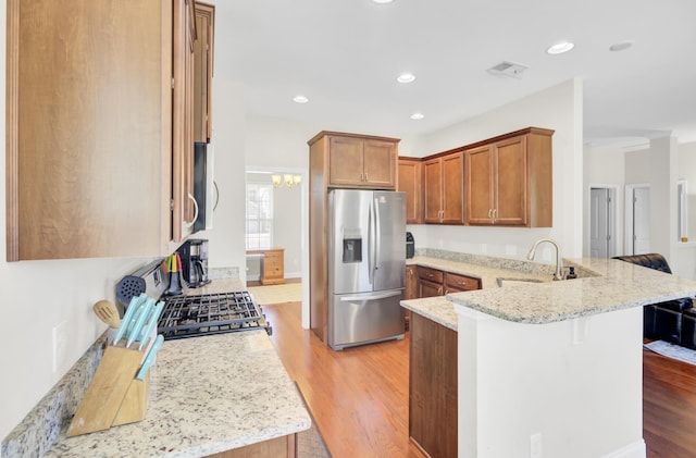 308 Legendres Dr, Goose Creek, SC 29445 - kitchen featuring stainless steel appliances, a peninsula, a sink, light wood-style floors, and light stone counters