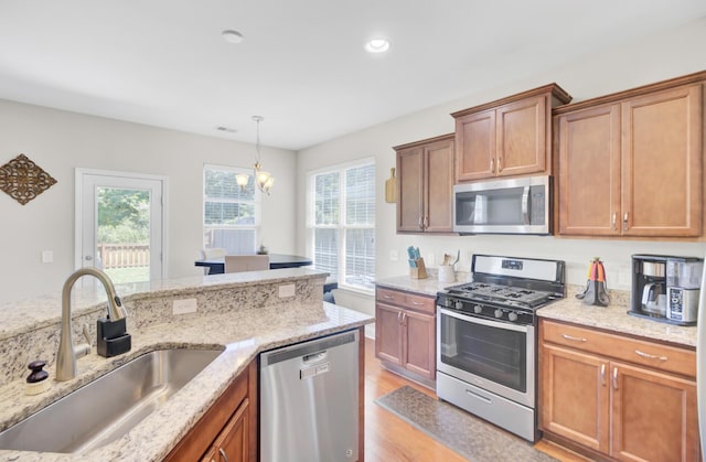 308 Legendres Dr, Goose Creek, SC 29445 - kitchen featuring stainless steel appliances, a sink, light wood-type flooring, light stone countertops, and a chandelier