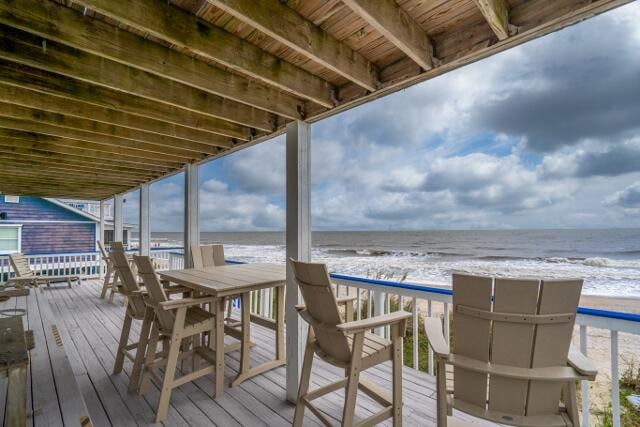 deck featuring a beach view and a water view