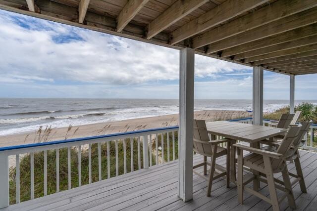 deck with a water view and a beach view