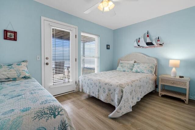 bedroom featuring access to outside, hardwood / wood-style floors, and ceiling fan