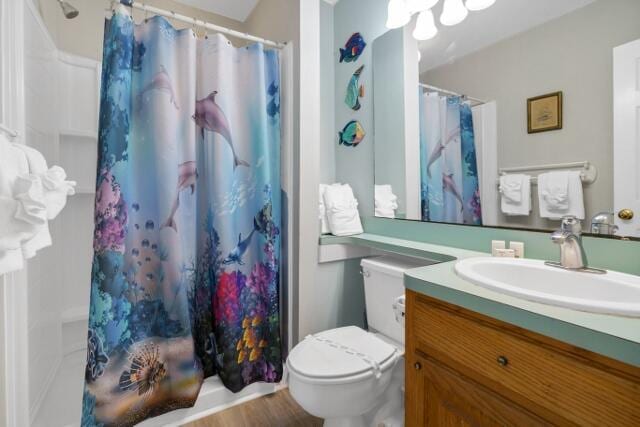 bathroom with a shower with curtain, hardwood / wood-style flooring, vanity, and toilet