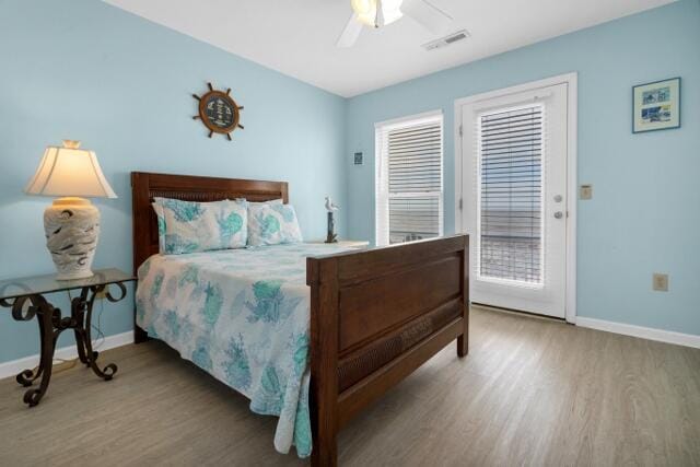 bedroom with hardwood / wood-style floors, ceiling fan, and access to exterior