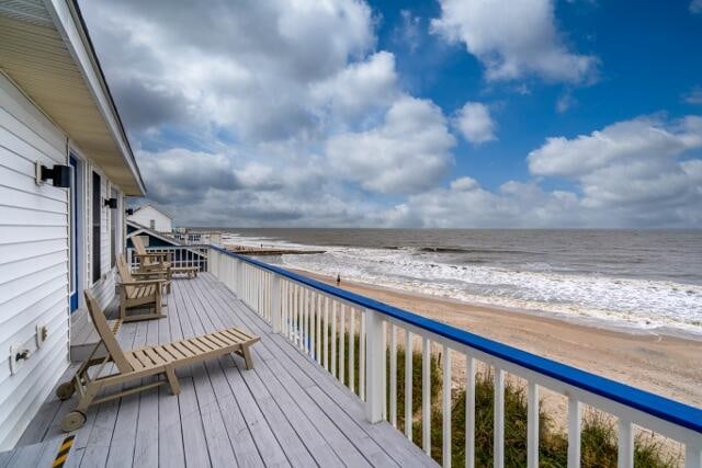 deck with a water view and a beach view