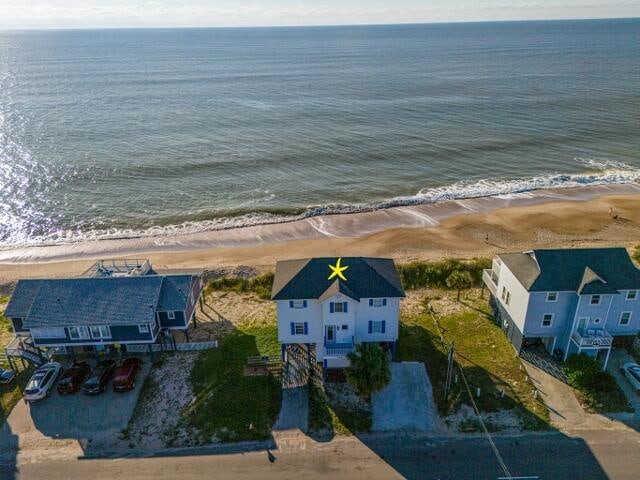 birds eye view of property featuring a beach view and a water view