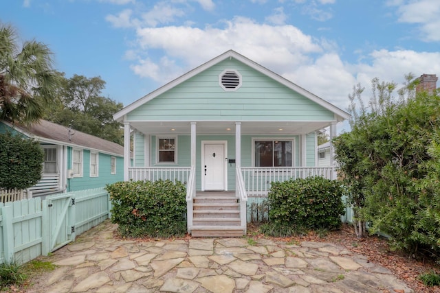 view of front of home with a gate, covered porch, and fence