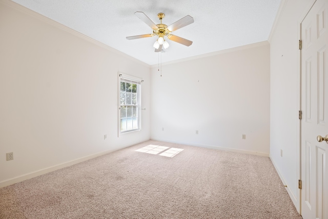 empty room featuring baseboards, ornamental molding, a ceiling fan, and carpet flooring