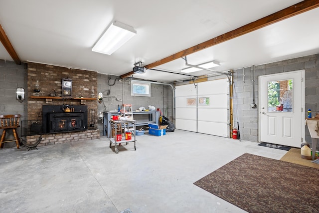 garage featuring a wood stove, concrete block wall, and a garage door opener