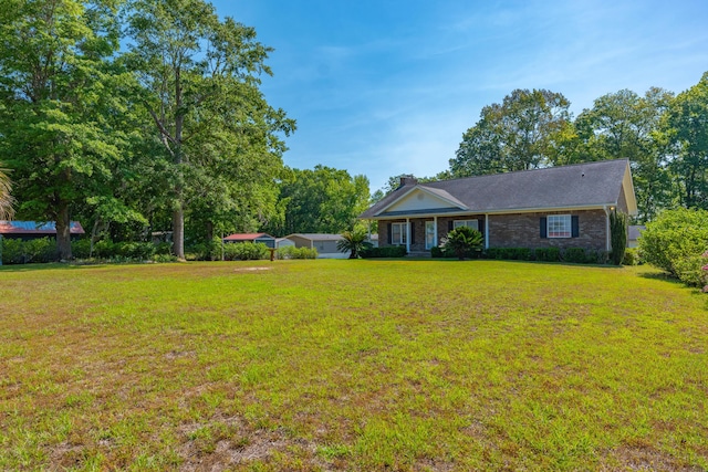 single story home with brick siding, a chimney, and a front lawn