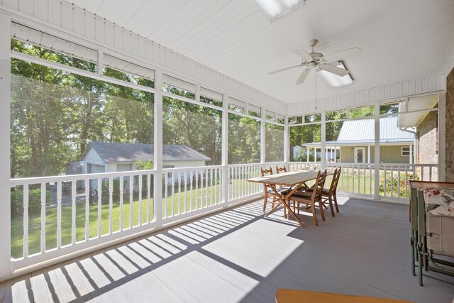 sunroom / solarium with a ceiling fan, outdoor dining space, and a wealth of natural light