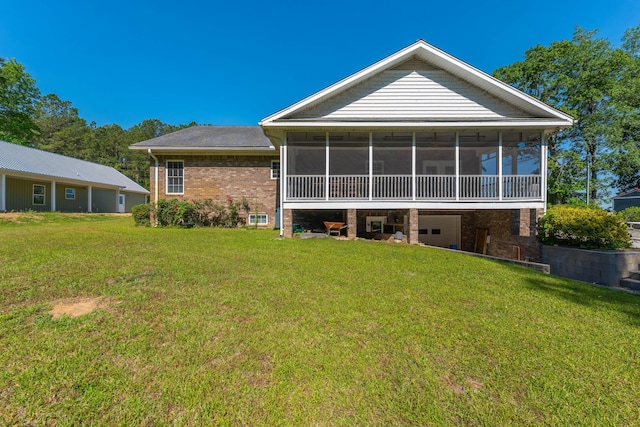 rear view of property with a lawn, a garage, a sunroom, and brick siding