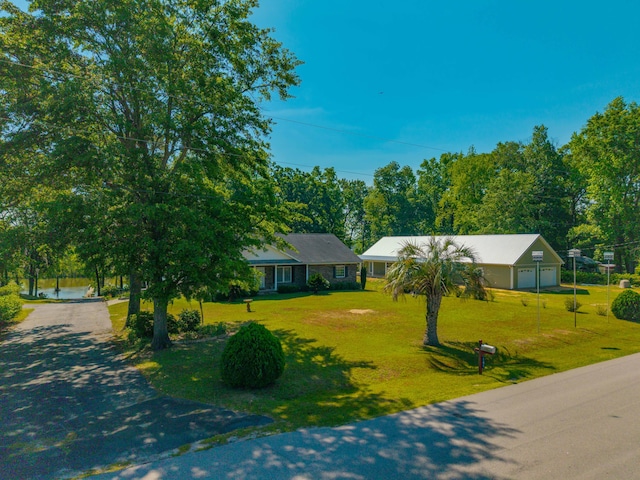 ranch-style house with driveway, a front yard, and a garage