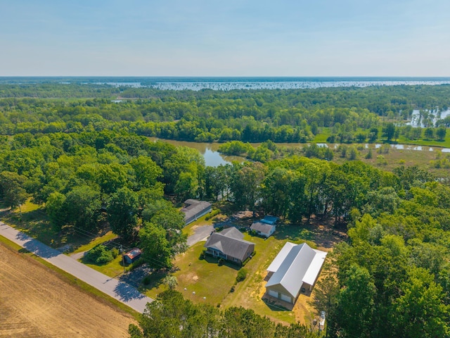 birds eye view of property featuring a water view and a wooded view