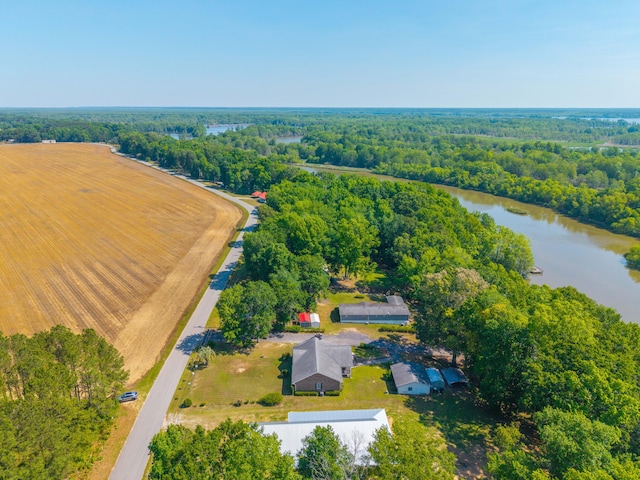 birds eye view of property featuring a water view and a wooded view