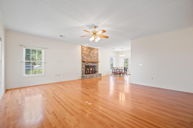 unfurnished living room with a ceiling fan, visible vents, a healthy amount of sunlight, and light wood finished floors