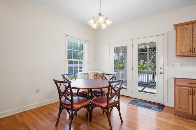 dining area with baseboards, a notable chandelier, ornamental molding, and light wood-style floors