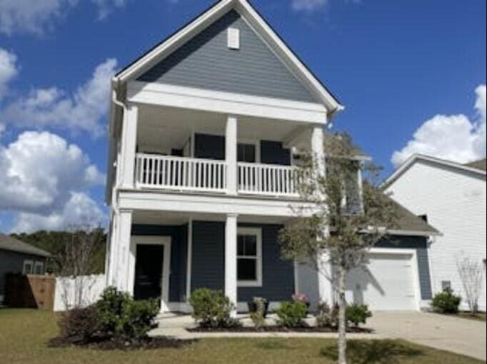 view of front facade featuring covered porch, a balcony, and a garage