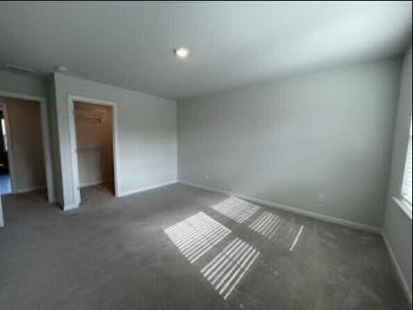 unfurnished bedroom with a closet and dark colored carpet