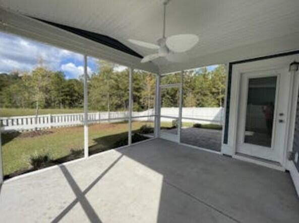 unfurnished sunroom with ceiling fan and vaulted ceiling