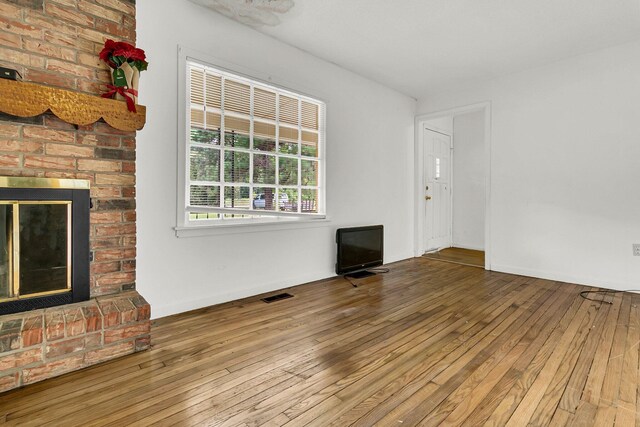 unfurnished living room with hardwood / wood-style floors and a fireplace