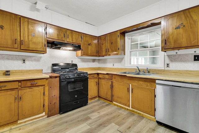 kitchen featuring light hardwood / wood-style flooring, sink, stainless steel dishwasher, and black gas range