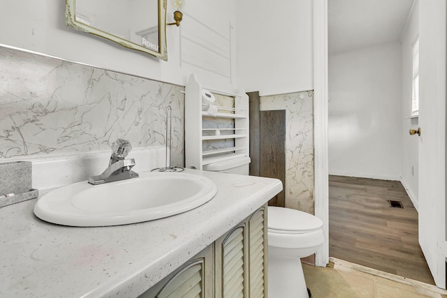 bathroom with vanity, wood-type flooring, and toilet