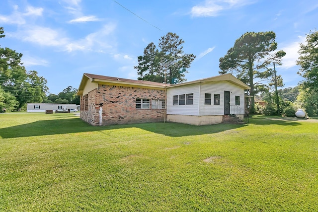 rear view of property with a lawn