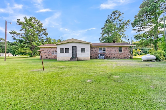 back of property featuring cooling unit and a lawn