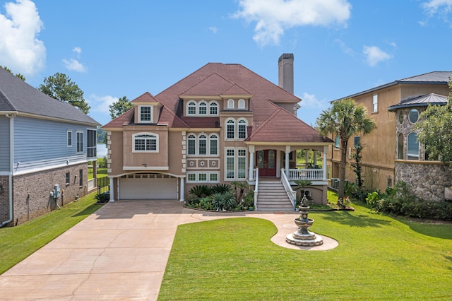 view of front facade with a porch, a garage, and a front lawn