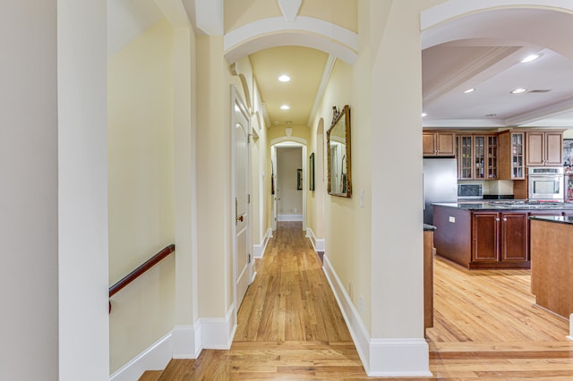 hall featuring ornamental molding and light hardwood / wood-style floors