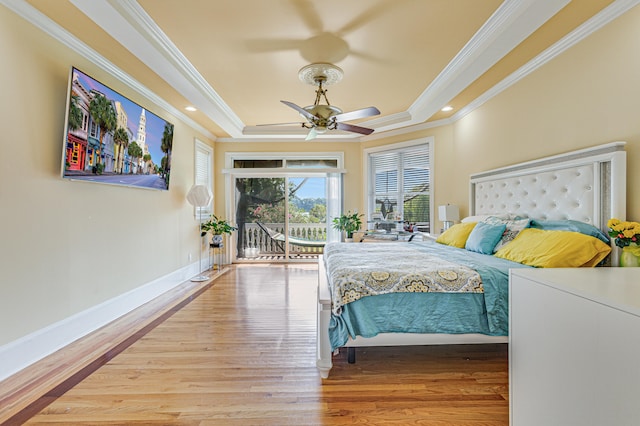 bedroom with ceiling fan, access to outside, a raised ceiling, ornamental molding, and light wood-type flooring