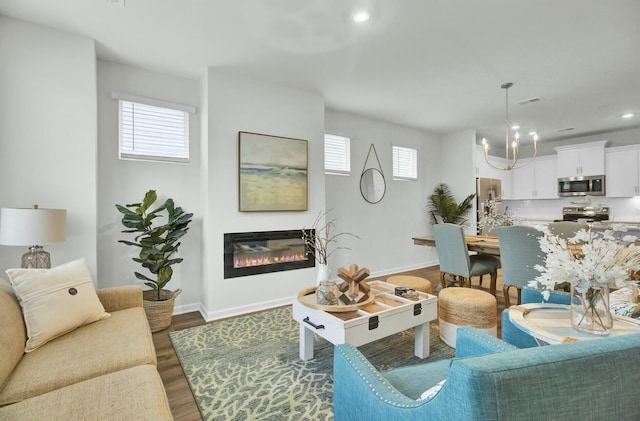 living room featuring an inviting chandelier and dark hardwood / wood-style flooring