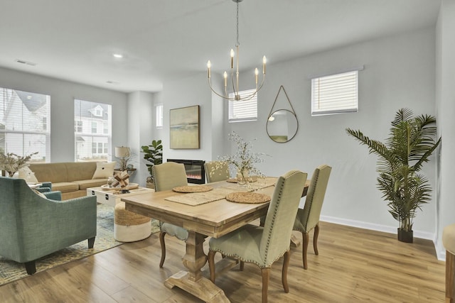 dining area with light hardwood / wood-style floors and a chandelier