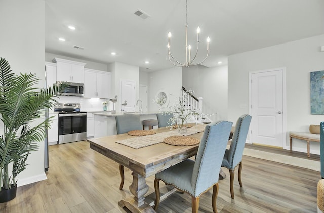 dining area with a notable chandelier and light wood-type flooring