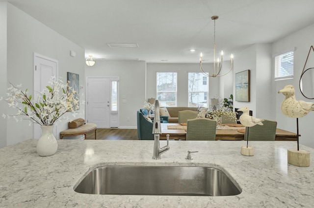 kitchen with hanging light fixtures, plenty of natural light, and light stone countertops