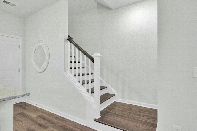 stairway with vaulted ceiling and hardwood / wood-style floors