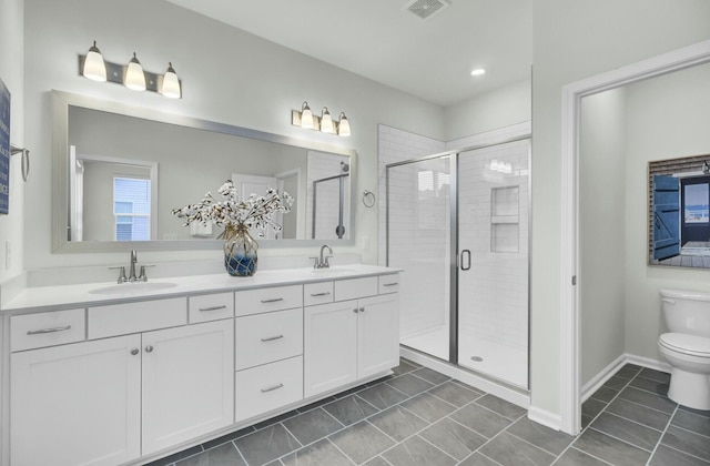 bathroom with tile patterned floors, vanity, toilet, and an enclosed shower