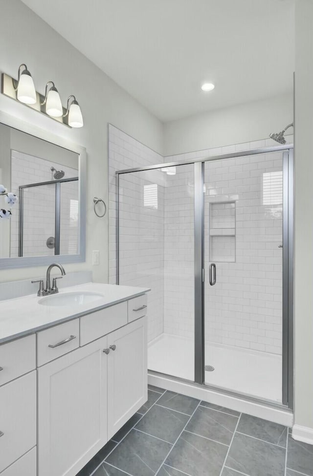 bathroom featuring vanity, tile patterned flooring, and a shower with door