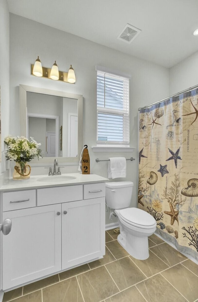 bathroom with vanity, tile patterned flooring, curtained shower, and toilet