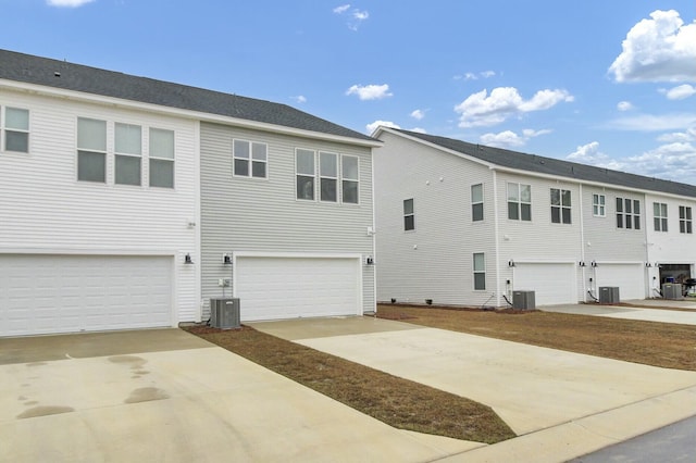 view of property exterior with a garage and cooling unit