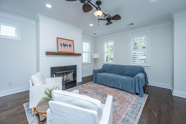 living area with ceiling fan, baseboards, a fireplace, crown molding, and healthy amount of natural light